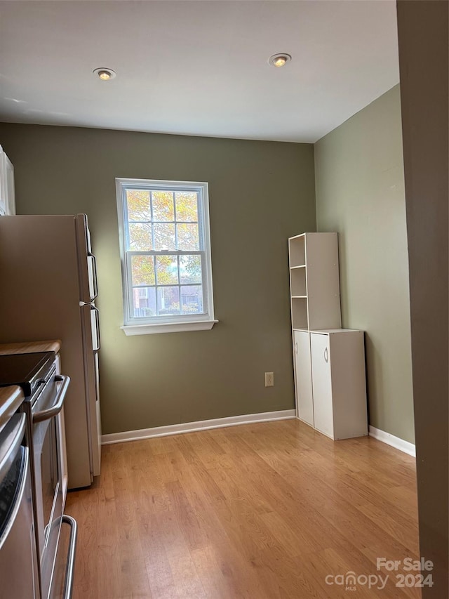 kitchen with white cabinetry, light hardwood / wood-style flooring, and electric range