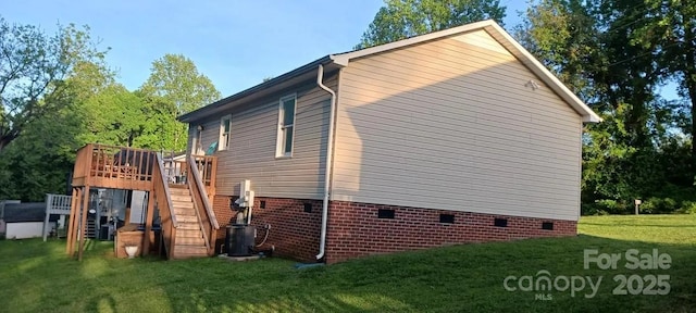 view of property exterior featuring a lawn, a wooden deck, and cooling unit