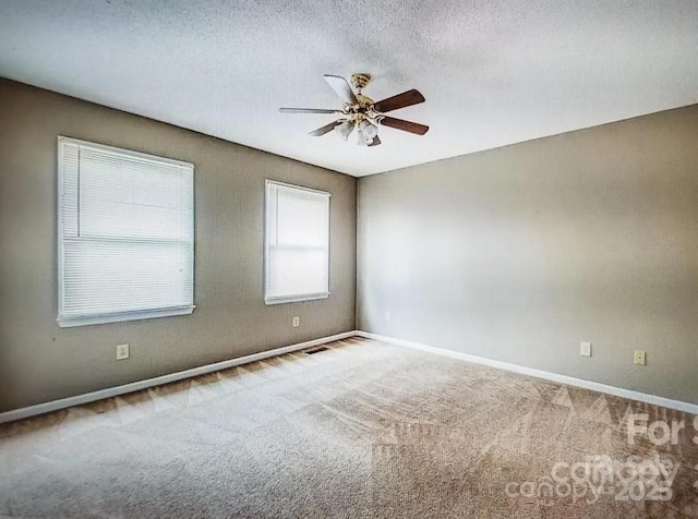 carpeted spare room with a textured ceiling and ceiling fan