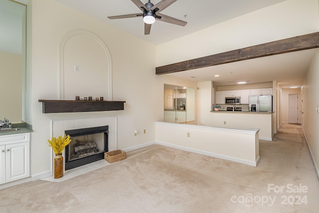 unfurnished living room featuring ceiling fan, light colored carpet, a fireplace, and sink