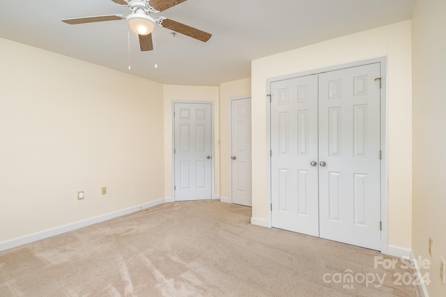 unfurnished bedroom featuring light carpet and ceiling fan