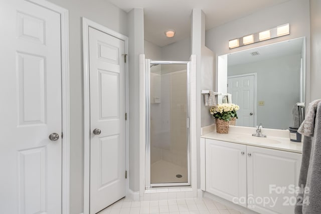 bathroom featuring walk in shower, vanity, and tile patterned floors