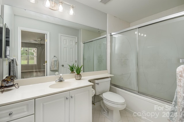 full bathroom with shower / bath combination with glass door, vanity, toilet, and tile patterned floors