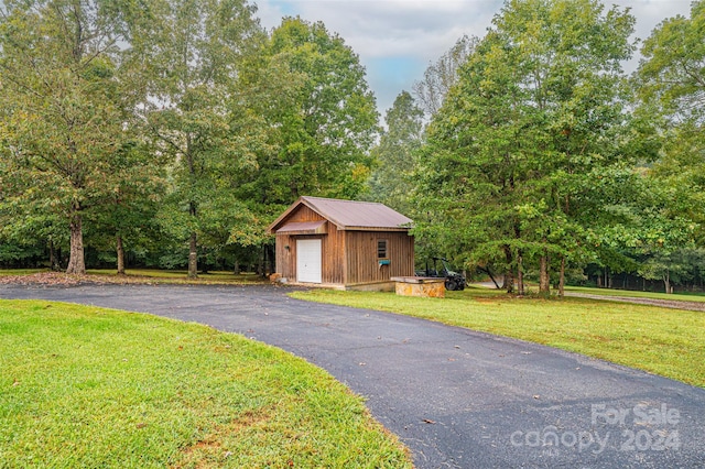 view of front facade featuring a front lawn, an outdoor structure, and a garage