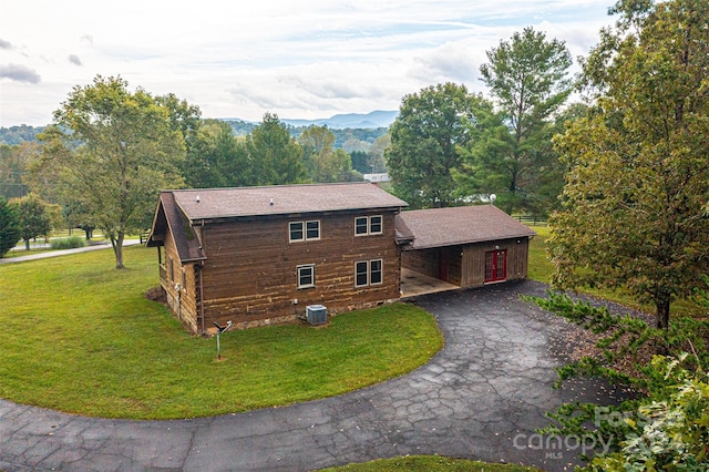 view of front facade featuring a front yard, a mountain view, and central AC