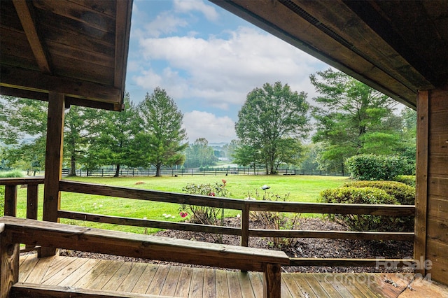 deck with a yard and a rural view