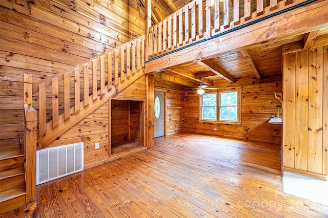 interior space featuring wooden ceiling, beam ceiling, wooden walls, and hardwood / wood-style flooring