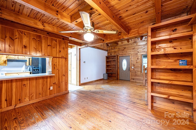 spare room featuring ceiling fan, wooden walls, light wood-type flooring, and wooden ceiling