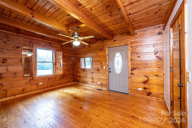 foyer with a healthy amount of sunlight, light hardwood / wood-style floors, beam ceiling, and ceiling fan