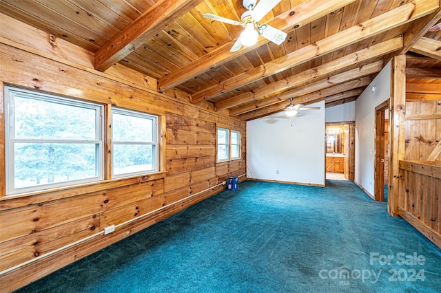 carpeted spare room with wood ceiling, wood walls, ceiling fan, and lofted ceiling with beams