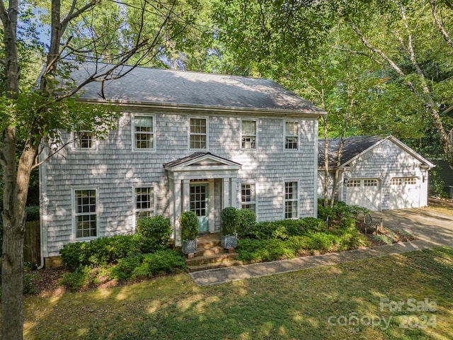 colonial house with a front yard and a garage