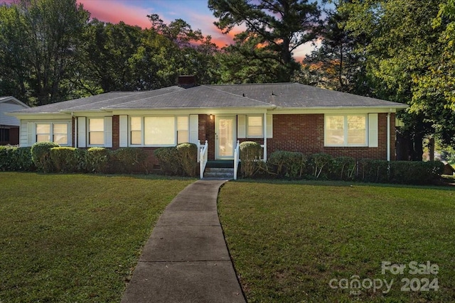 ranch-style home featuring a lawn