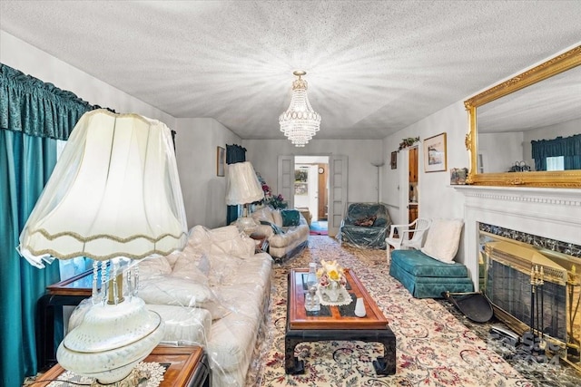 living room featuring a high end fireplace, an inviting chandelier, and a textured ceiling