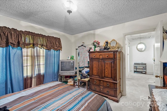 bedroom featuring a textured ceiling and light colored carpet