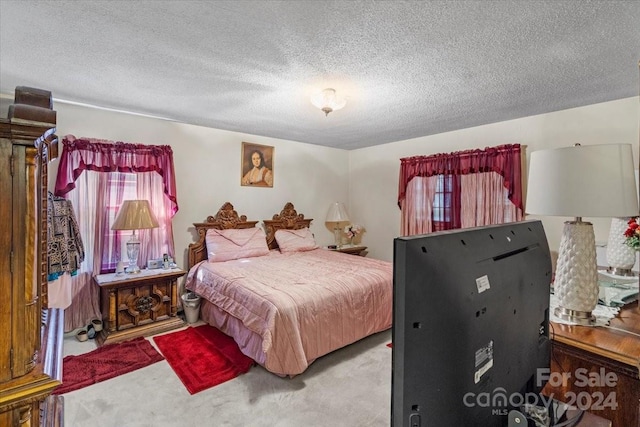 carpeted bedroom featuring a textured ceiling