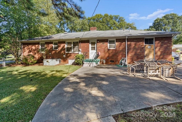 rear view of property featuring a lawn and a patio