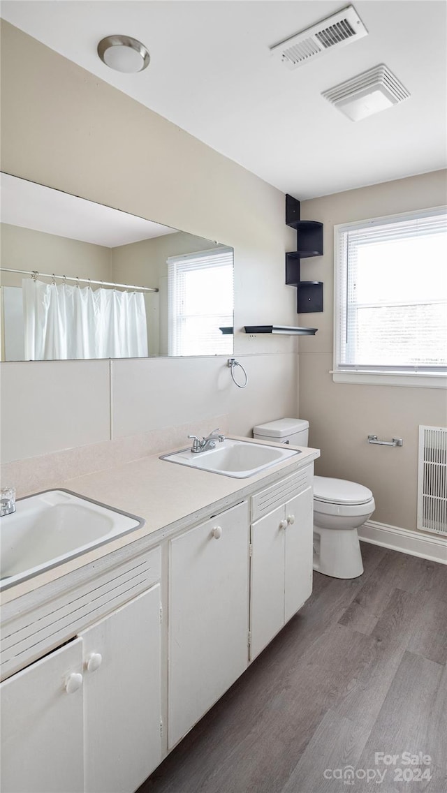 bathroom featuring vanity, hardwood / wood-style flooring, toilet, and a shower with shower curtain