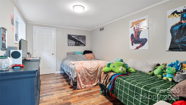 bedroom featuring crown molding and hardwood / wood-style flooring