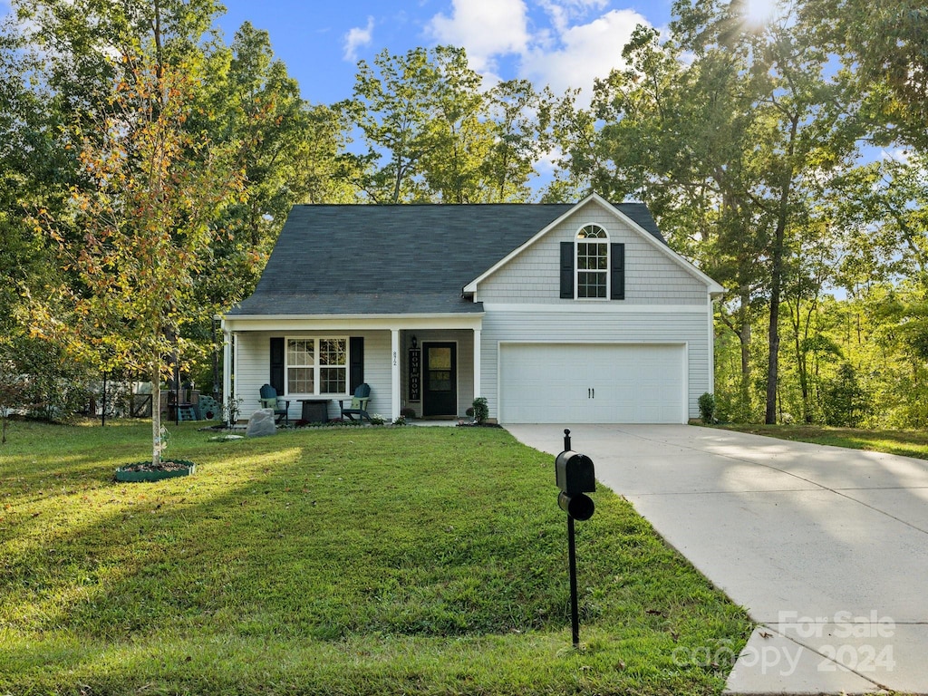 view of front facade with a garage, a front lawn, and a porch