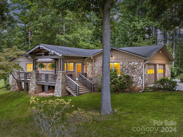 view of front of home with a wooden deck and a front lawn