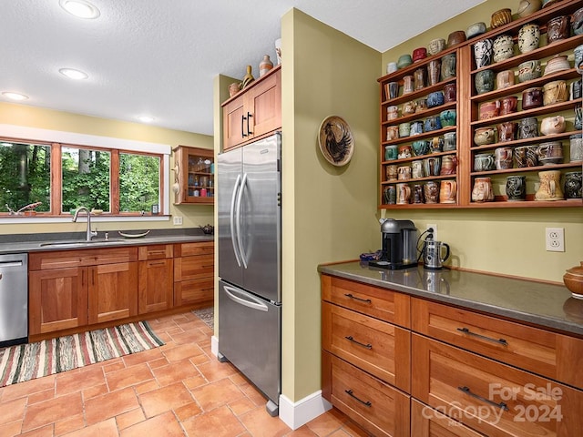 kitchen featuring appliances with stainless steel finishes, a textured ceiling, and sink