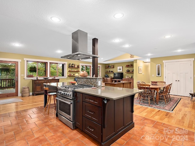 kitchen with a center island, light wood-type flooring, stainless steel stove, and extractor fan