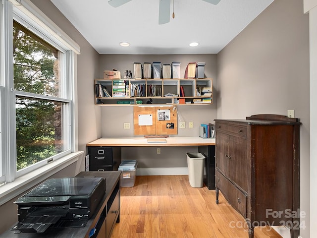 office featuring built in desk, ceiling fan, light hardwood / wood-style flooring, and plenty of natural light