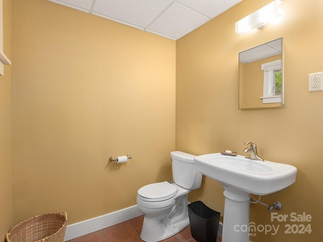 bathroom with toilet, tile patterned floors, and a paneled ceiling