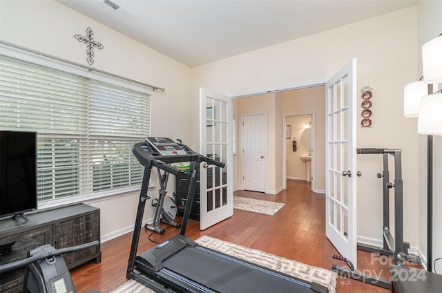 exercise room with dark hardwood / wood-style floors, french doors, and sink