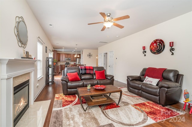 living room with ceiling fan, a fireplace, and hardwood / wood-style floors