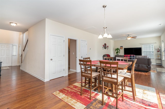 dining room featuring ceiling fan with notable chandelier and dark hardwood / wood-style floors