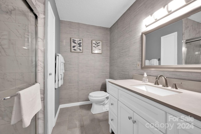 bathroom with vanity, toilet, a textured ceiling, walk in shower, and tile patterned flooring