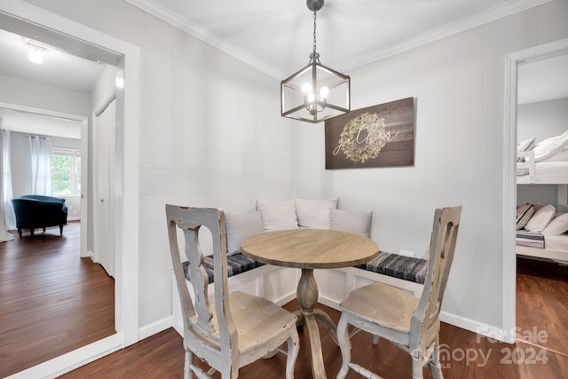 dining space featuring an inviting chandelier, breakfast area, crown molding, and dark wood-type flooring