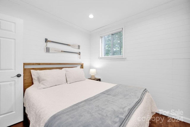 bedroom with ornamental molding and dark hardwood / wood-style flooring