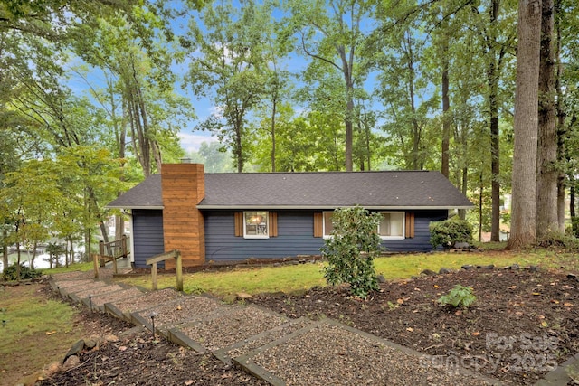 view of front of house featuring a shingled roof and a chimney