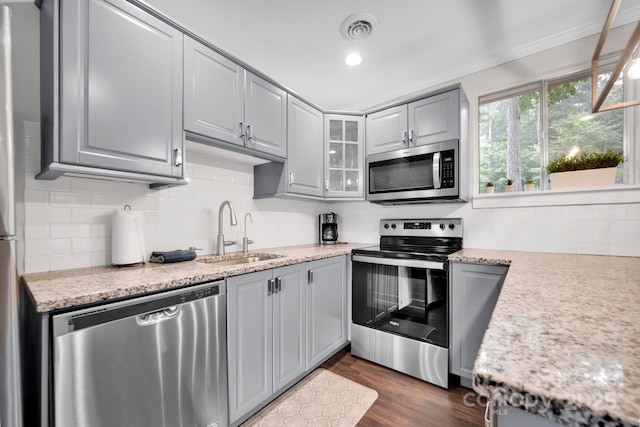 kitchen featuring visible vents, gray cabinets, a sink, appliances with stainless steel finishes, and dark wood-style flooring