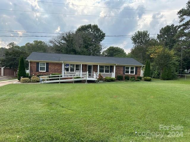 ranch-style home featuring a porch and a front lawn