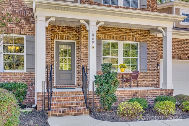 entrance to property featuring a garage and a porch