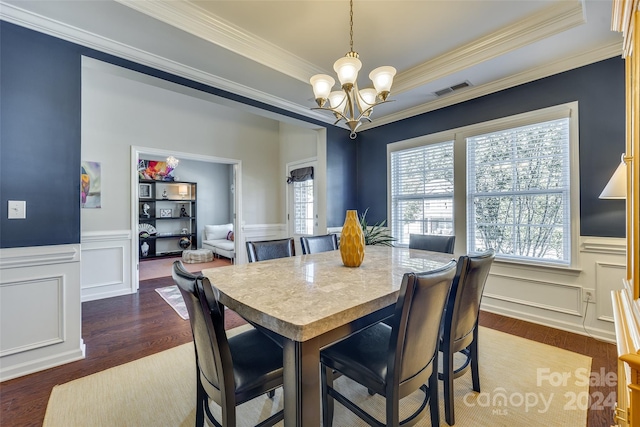 dining room featuring crown molding, an inviting chandelier, dark hardwood / wood-style floors, and a raised ceiling