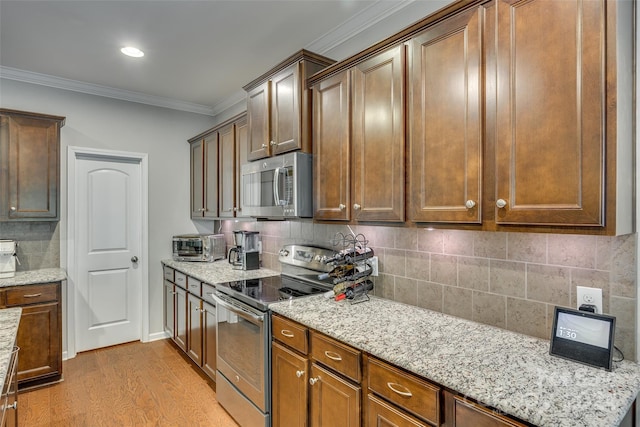 kitchen with light stone countertops, decorative backsplash, ornamental molding, light hardwood / wood-style floors, and appliances with stainless steel finishes