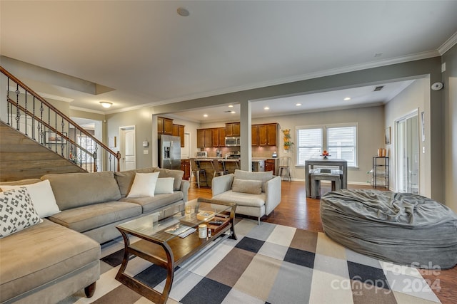 living room featuring crown molding and light hardwood / wood-style flooring