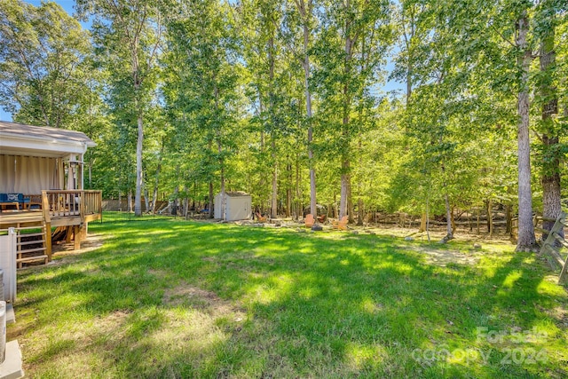 view of yard featuring a wooden deck and a shed