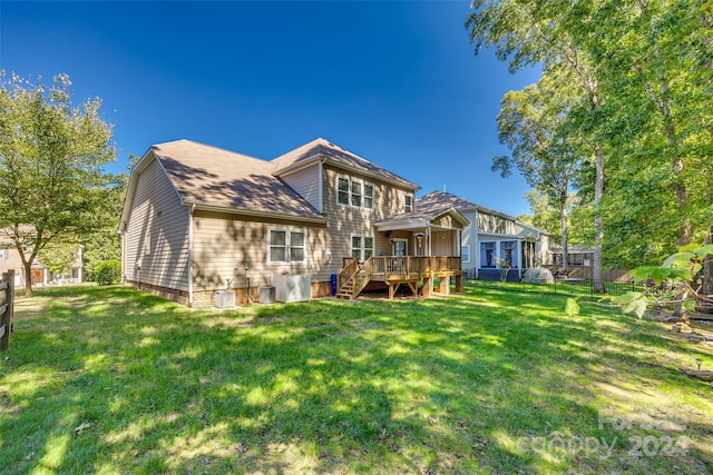 rear view of property featuring a yard and a deck