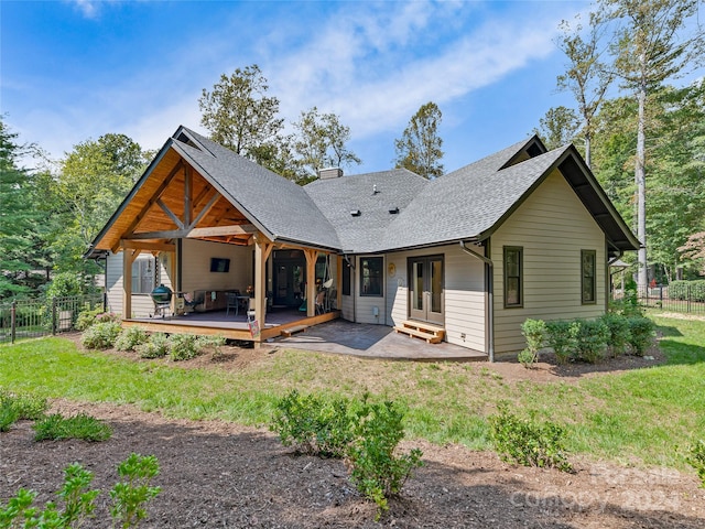 back of house with a wooden deck, a patio area, and a lawn