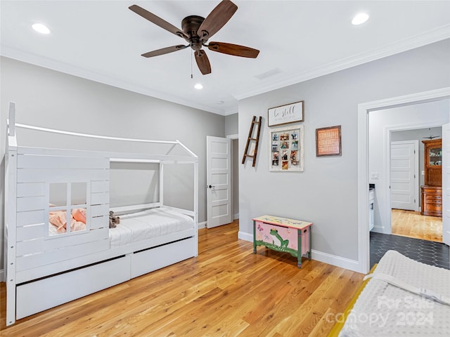 bedroom featuring light hardwood / wood-style flooring, crown molding, and ceiling fan