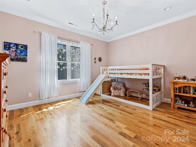 bedroom with a notable chandelier, hardwood / wood-style flooring, and ornamental molding