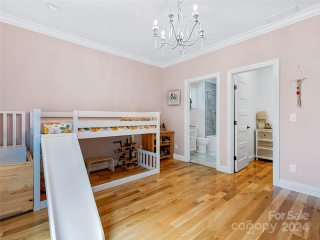 bedroom featuring ornamental molding, hardwood / wood-style floors, a chandelier, and connected bathroom