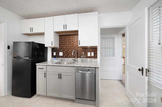 21 Lakeshore Dr, Asheville, NC 28804 - kitchen with stainless steel dishwasher, freestanding refrigerator, a sink, decorative backsplash, and light tile patterned flooring