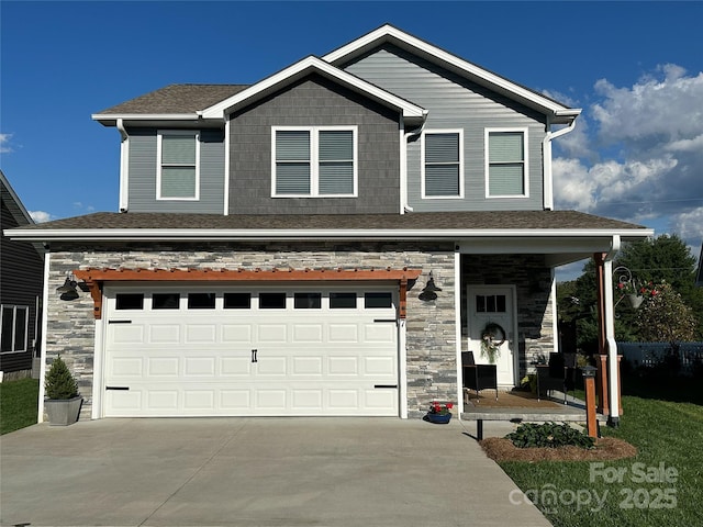 craftsman-style house with stone siding, concrete driveway, and an attached garage