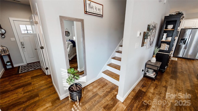 staircase with baseboards and wood finished floors